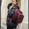 Mochila Ardilla roja Chica con casaca negra y mochila roja al hombro