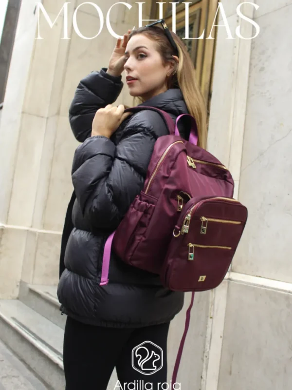 Mochila Ardilla roja Chica con casaca negra y mochila roja al hombro